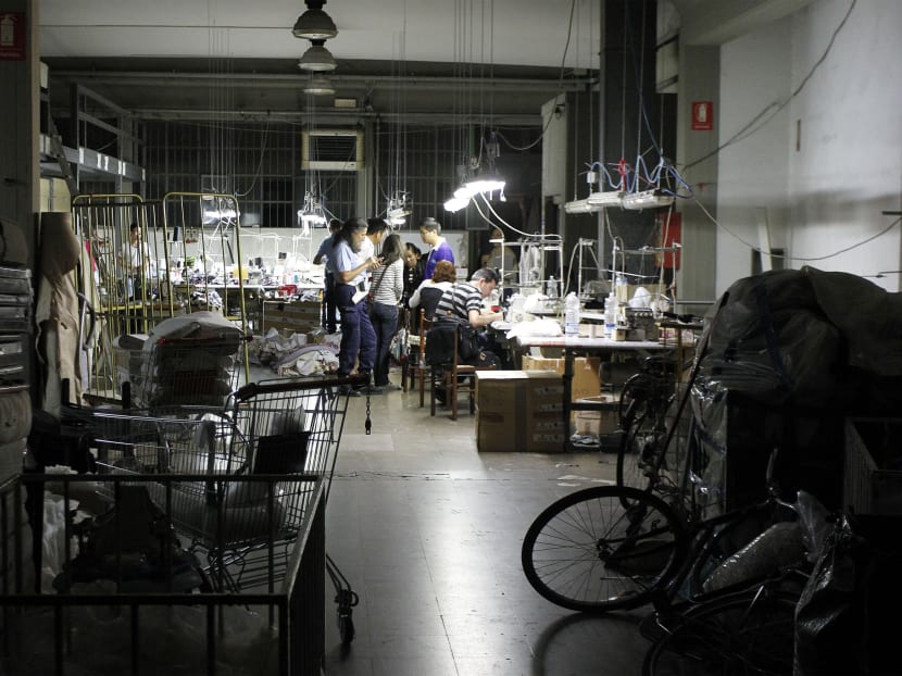 In this June 19, 2014 photo, police officers inspect a sequestered textile factory in Prato, Italy. The compound, which had been divided into four different factories, was closed because of illegal bedrooms, too few fire extinguishers, no well-marked, easily accessible fire exits, no first aid kit and a dozen gas canisters found during the raid. Photo: AP