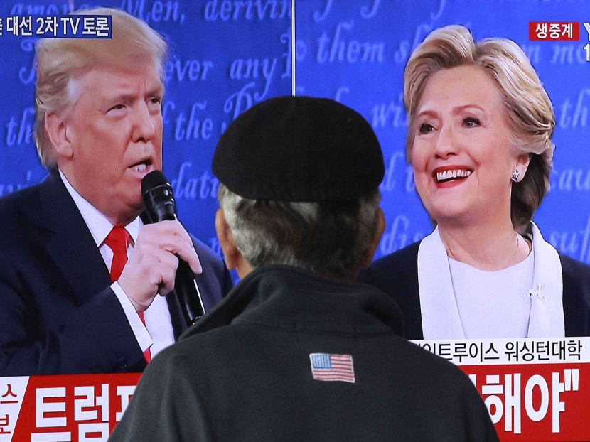 A man watches a TV screen showing the live broadcast of the US presidential debate between Democratic presidential nominee Hillary Clinton and Republican presidential nominee Donald Trump, at Seoul Railway Station in Seoul, South Korea, on Oct 10, 2016. Photo: AP