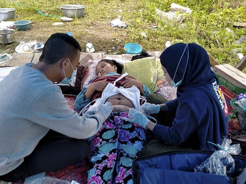 An injured woman is treated in a makeshift hospital in Majene on Jan 17, 2021, after a 6.2-magnitude earthquake rocked Indonesia's Sulawesi island.