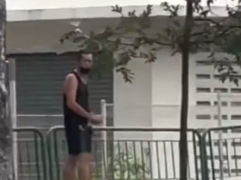 A screengrab of a video that appears to show a man standing on the side of Simei Avenue, throwing objects at passing vehicles.