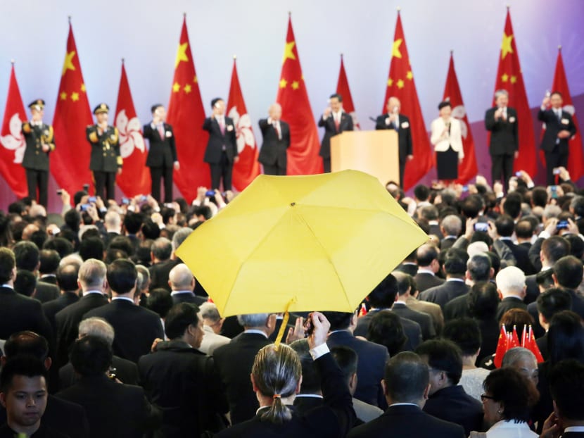 Mr Paul Zimmerman, a district councillor, raising a yellow umbrella during a flag-raising ceremony celebrating China’s 65th National Day. Photo: REUTERS