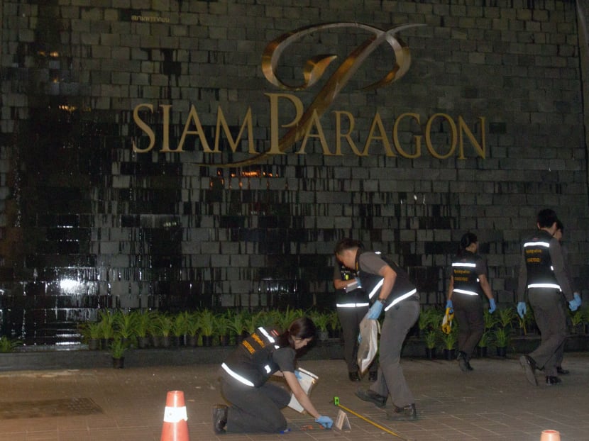 Thai police forensic officers investigate near the front of the Siam Paragon shopping mall, the site of a blast in Bangkok, Thailand, Feb 1, 2015. Photo: AP