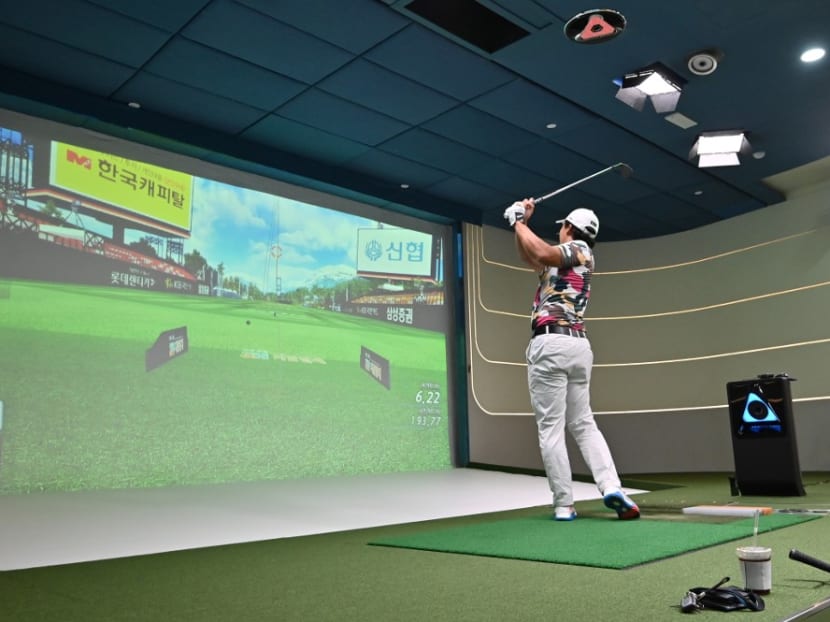A South Korean golfer hits a ball in a simulation booth during the GTour screen golf tournament in Daejeon, south of Seoul, July 24, 2020.