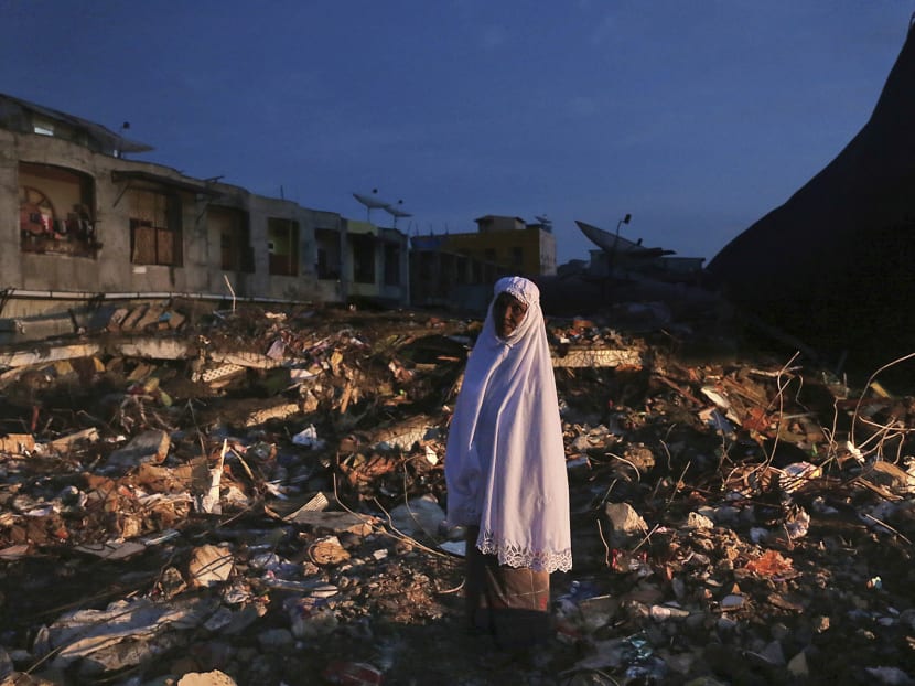 A woman stands on the ruins of a market after Wednesday's earthquake in Meureudu, Aceh province, Indonesia, Dec 8, 2016. Photo: AP