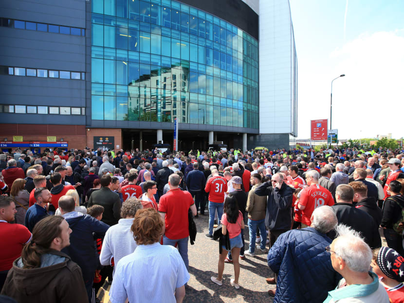Spectators stand outside of Old Trafford stadium after today's final soccer match of the season between Manchester United and AFC Bournemouth was abandoned due to a suspect package being found inside the stadium. Sunday May 15, 2016. Photo: AP