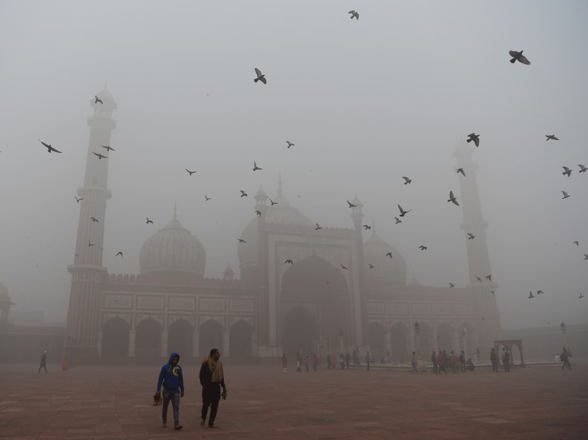 Indian visitors walk through the courtyard of Jama Masjid amid heavy smog in the old quarters of New Delhi on November 8, 2017. Photo: AFP