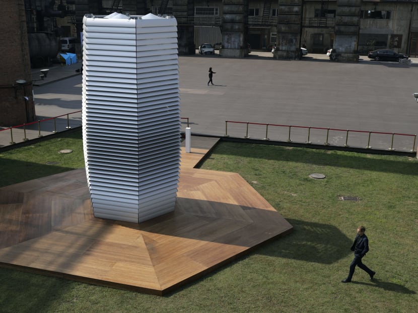 Dutch artist Daan Roosegaarde, right, walks past his Smog Free Tower on display at D-751art district in Beijing, Thursday, Sept. 29, 2016. Photo: AP