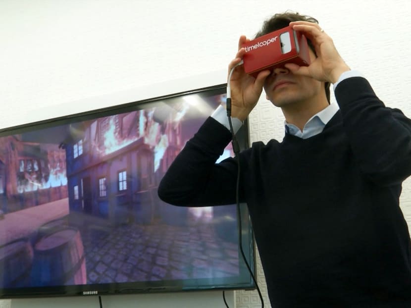 This Feb. 2, 2016 image made from video shows Timelooper co-founder Yigit Yigiter looking through a Google cardboard virtual reality headset as he sees a recreation of the Great Fire of London in 1666. Photo: AP