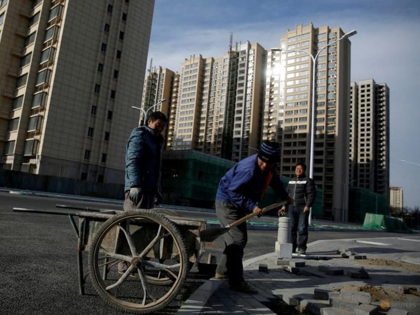 FILE PHOTO: Men work near residential apartment blocks under construction on the outskirts of Beijing, China November 29, 2017. REUTERS/Thomas Peter/File Photo