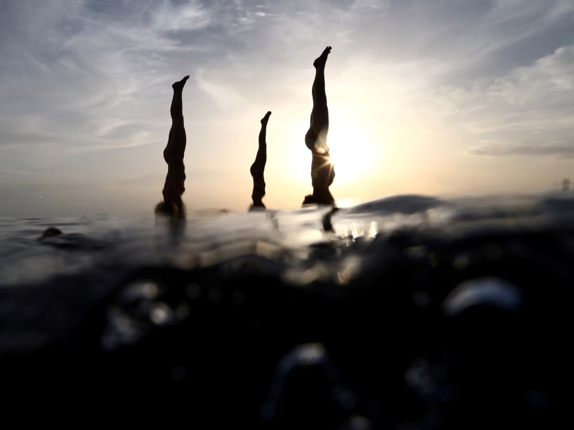 People practise standup paddleboard yoga, or SUP yoga, on the Adriatic coast in Verudela, Croatia. Photo: Reuters
