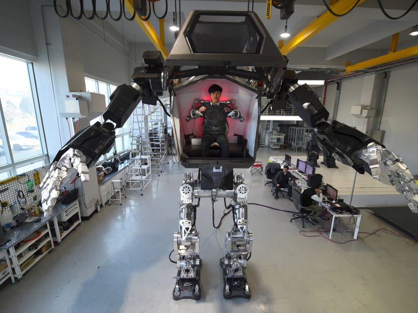 Engineers test a four-metre-tall humanoid manned robot dubbed Method-2 in a lab of the Hankook Mirae Technology in Gunpo, south of Seoul, on December 27, 2016. The giant human-like robot bears a striking resemblance to the military robots starring in the movie "Avatar" and is claimed as a world first by its creators from a South Korean robotic company. Photo: AFP