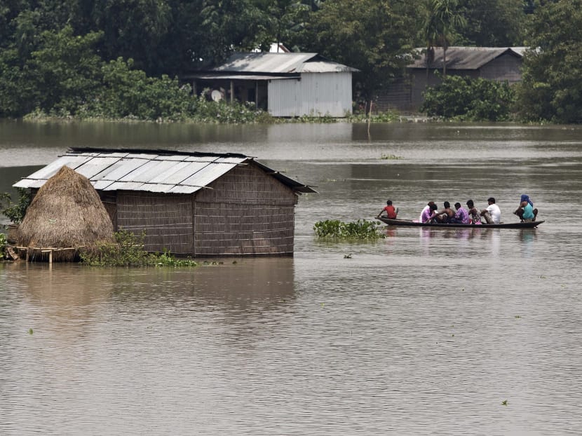 Flood affected people travel in a boat near partially submerged houses in Morigaon district east of Gauhati, Assam, India, Tuesday, Aug. 15, 2017. Heavy monsoon rains have unleashed landslides and floods that killed dozens of people in recent days and displaced millions more across northern India, southern Nepal and Bangladesh. Photo: AP
