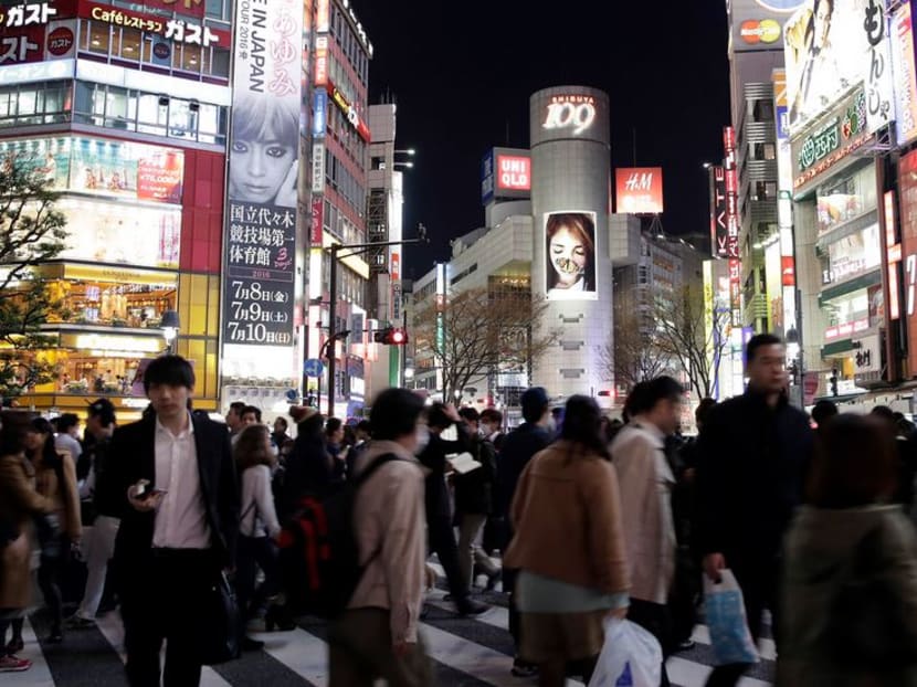 Pedestrians cross an intersection at dusk in the Shibuya district of Tokyo. Photo: BLOOMBERG