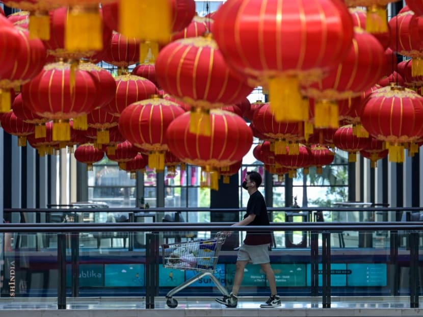A shopper walks in a hallway with lantern decorations for Chinese New Year celebrations at a shopping mall in Kuala Lumpur on Wednesday, Feb 3, 2021.