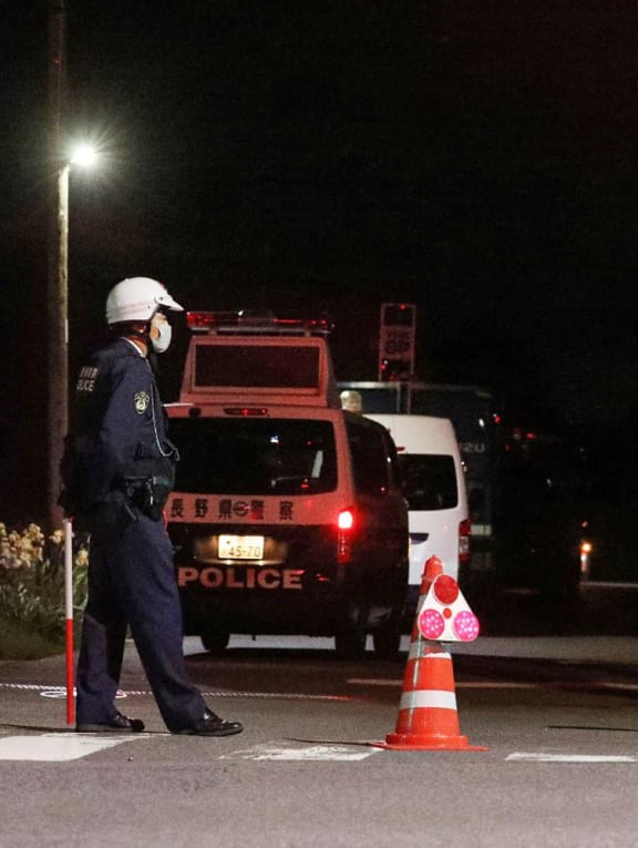 Police officers stand guard near the scene of a standoff where a suspect, believed to be a farmer in his 30s, was holed up inside a building in the Ebe area of Nakano, Nagano Prefecture, Japan, late on May 25, 2023