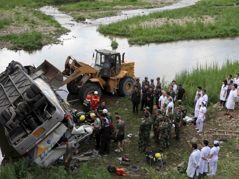 Rescue workers search at the site of a traffic accident, where a bus fell off a bridge, in Ji'an, Jilin province, China, July 1, 2015. Photo: Reuters