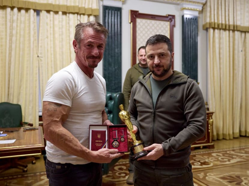 Handout picture by Ukraine's presidential press-service on Nov 8, 2022 shows Mr Volodymyr Zelensky (right) posing with United States actor Sean Penn (left) after receiving latter's Oscar statuette and handing him the Order of Merit, III degree during their meeting in Kyiv.