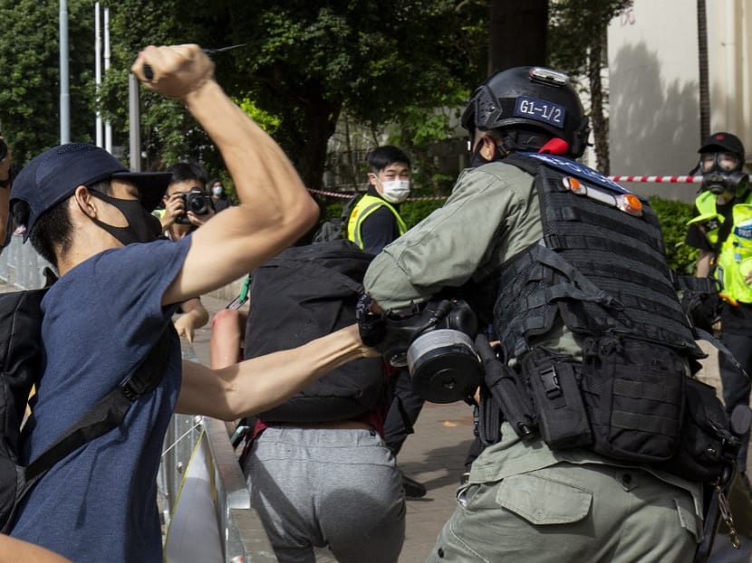 A protester uses a sharp object against a police officer who is trying to detain a man during a rally against a new national security law in Hong Kong on July 1, 2020.