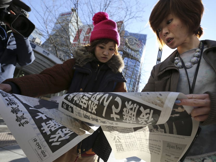 Japanese women react as they read extra newspapers in Tokyo reporting about an online video that purported to show an Islamic State group militant beheading Japanese journalist Kenji Goto, this morning (Feb 2). The headline reads: "A video on killing of Goto." Photo: AP