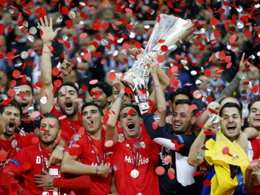 Sevilla's Fernando Navarro lifts the trophy as they celebrate winning the UEFA Europa League Final on May 27, 2015. Photo: Reuters