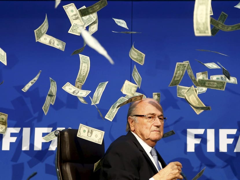 British comedian known as Lee Nelson (unseen) throws banknotes at FIFA President Sepp Blatter as he arrives for a news conference after the Extraordinary FIFA Executive Committee Meeting in this July 20, 2015 file photo. Photo: Reuters