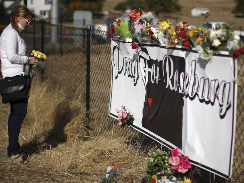 A woman leaves flowers at a memorial outside Umpqua Community College in Roseburg, Oregon. Photo: Reuters