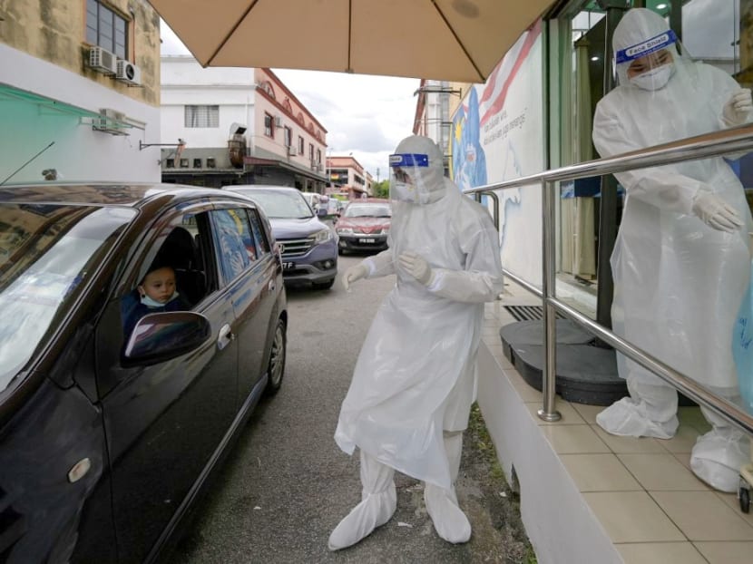 Medical personnel wearing protective suits conduct Covid-19 testing at a drive-through centre outside the Ajwa Private Clinic in Shah Alam on the outskirts of Kuala Lumpur, Malaysia on Jan 12, 2021.
