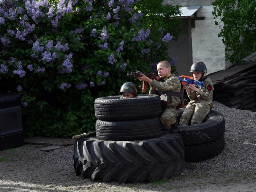 13-year-old Andriy Shyrokyh (centre)) and 10-year-old Maksym Mudrak, wearing battle fatigues and homemade body armour, play a war game in a village of Stoyanka, Kyiv, which was occupied by Russian troops during the beginning of the invasion last year 13-year-old Andriy Shyrokyh (centre)) and 10-year-old Maksym Mudrak, wearing battle fatigues and homemade body armour, play a war game in a village of Stoyanka, Kyiv, which was occupied by Russian troops during the beginning of the invasion last year