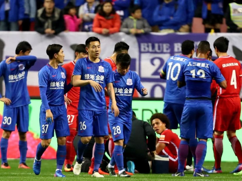 Shanghai Shenhua midfielder Qin Sheng (No 26) walking off after receiving his red card. On the ground is Axel Witsel, who he stamped on. Photo: AFP