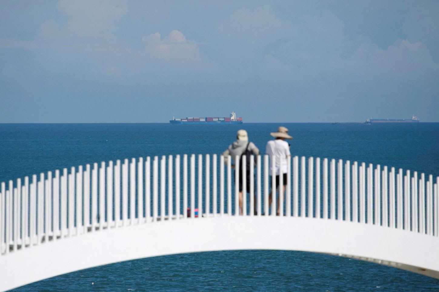 Tourists stand facing container ships in the waters off the 68-nautical-mile scenic spot, one of mainland China's closest points to the island of Taiwan, in Pingtan island, Fujian province, China on Aug 5, 2022. Tourists stand facing container ships in the waters off the 68-nautical-mile scenic spot, one of mainland China's closest points to the island of Taiwan, in Pingtan island, Fujian province, China on Aug 5, 2022.