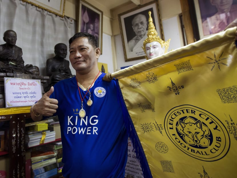 Korpsin Uiamsa-ard, a mentee of chief monk Phra Prommangkalachan at the Wat Traimitr Withayaram temple, holds up a Leicester City banner in Bangkok, Thailand, May 3, 2016. Photo: AP