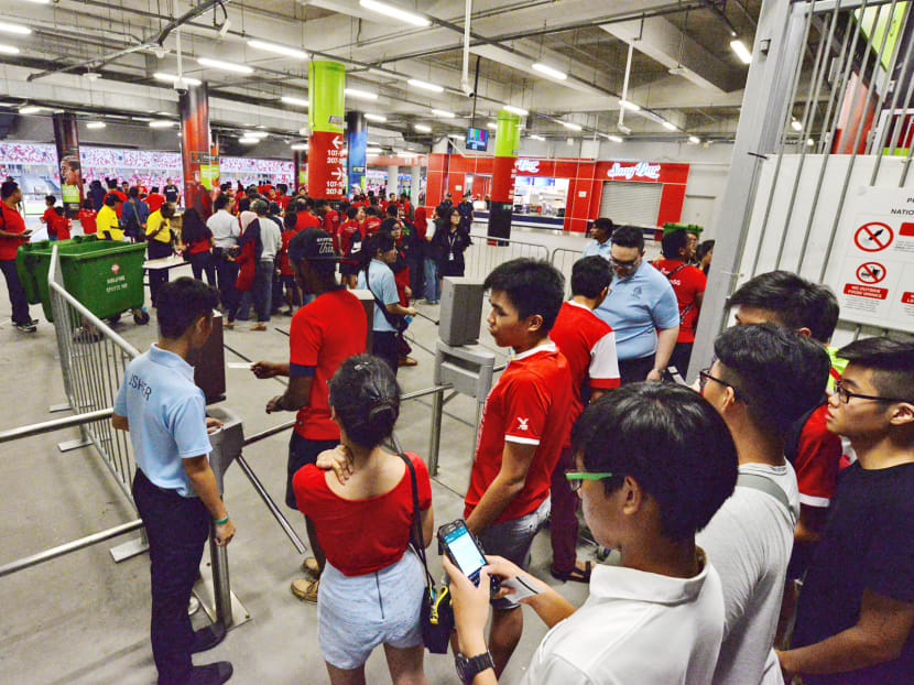 Sports Hub staff (in light blue) ushering at the entrance of the stadium before the Singapore vs Syria football match. Photo: Robin Choo
