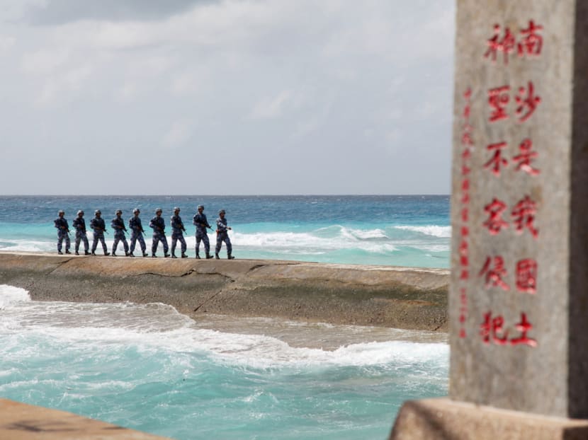 Members of China’s People’s Liberation Army Navy patrolling near a sign in the Spratly (or Nansha) Islands. Militarising artificial islands in these disputed waters is one part of Beijing’s ‘rejuvenation’ plan. PHOTO: REUTERS