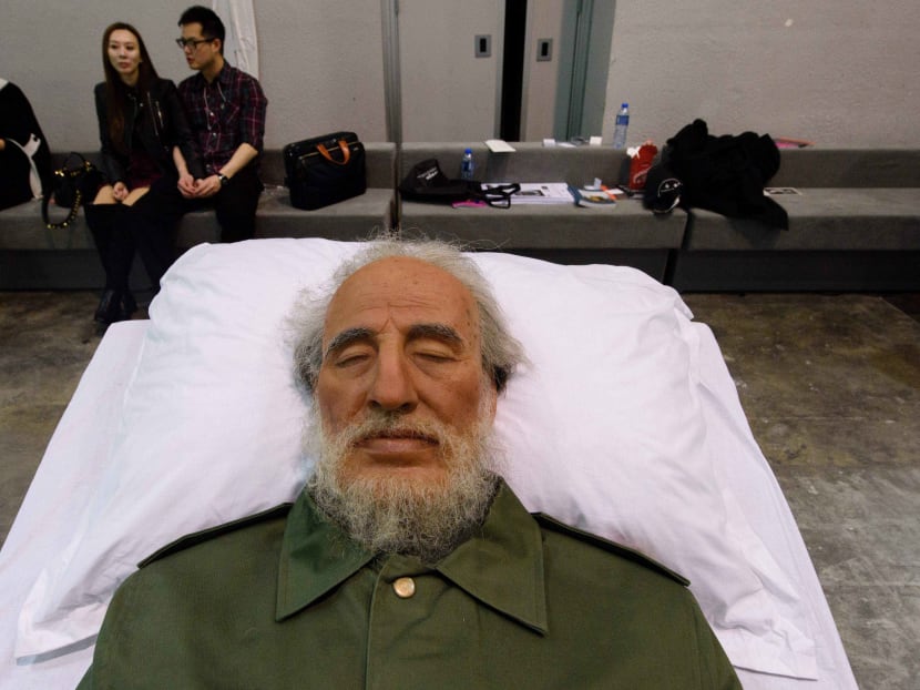 Visitors sit behind Chinese artist Shen Shaomin's Fidel Castro, part of his 'Summit' project, at Art Basel in Hong Kong on March 22, 2017. Photo: AFP