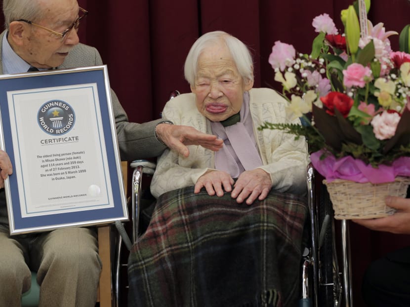 Japan's 114-year-old Misao Okawa, right, and her 90-year-old son Hiroshi Okawa pose with Guinness World Records certificate of the world's oldest living woman at her nursing home in Osaka. Photo: AP