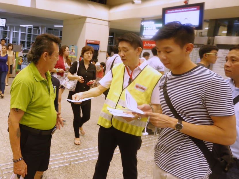 An SMRT staff giving out leaflets to commuters at Paya Lebar MRT. Photo: Ernest Chua/TODAY
