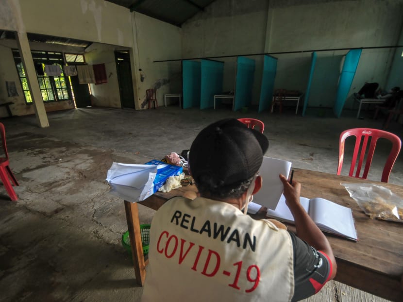 A volunteer keeps watch at a quarantine facility, a repurposed abandoned house believed by some locals to be haunted and used as a deterrent effect against those breaking social restrictions amid the Covid-19 coronavirus pandemic, at Sepat village in Sragen, Central Java, on April 21, 2020.