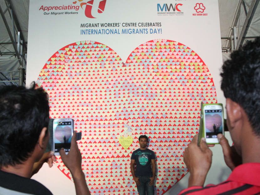 A migrant worker poses in front of an installation containing about 3,000 messages from Singaporeans thanking migrant workers for their contributions to our nation and migrant workers expressing their hopes and dreams for their future. The installation is the Migrant Workers' Centre's attempt to enter into the Singapore Book of Records for the "Largest Heart Formation made of Heart-shaped Notes", in celebration of International Migrants Day on Dec 7, 2014. Photo: Ooi Boon Keong