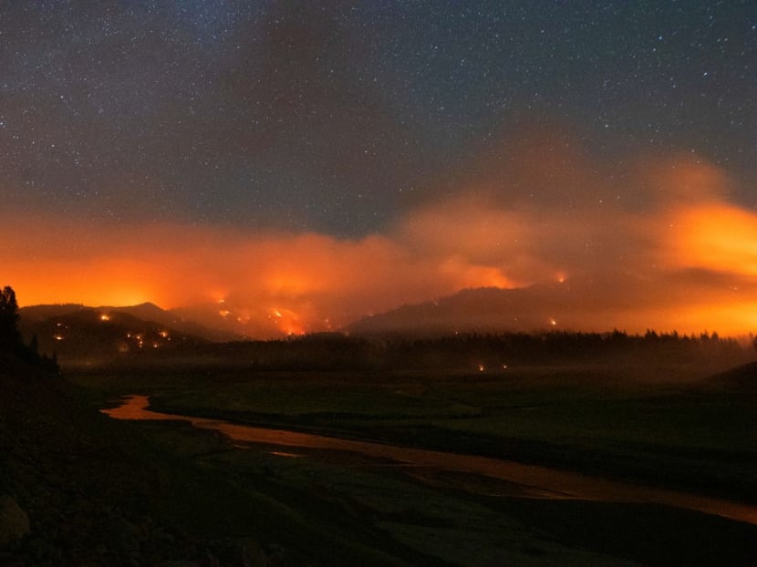 In this long exposure photograph, flames surround a drought-stricken Shasta Lake during the "Salt fire" in Lakehead, California early on July 2, 2021, as firefighters battle nearly a dozen wildfires in the region following a heatwave and multiple lightning strikes.