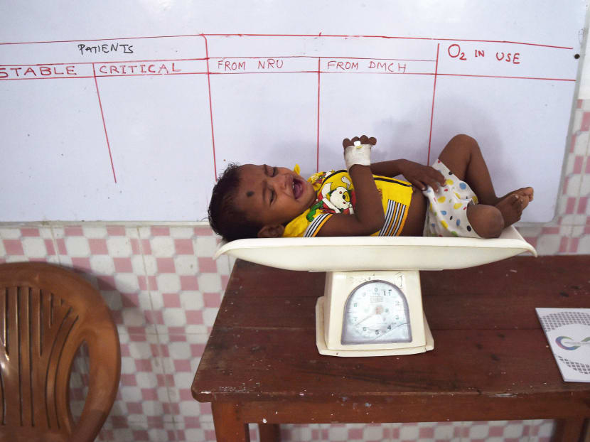 Dinesh Pandit lies on a scale in India’s eastern state of Bihar, which has one of the highest rates of malnutrition. PHOTO: AFP