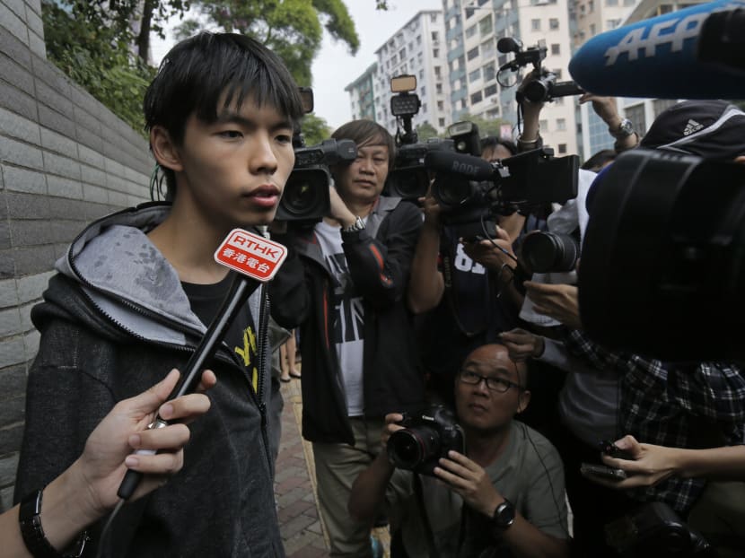 Prominent Hong Kong student protest leader Joshua Wong talks to reporters after two men allegedly threw eggs at him and his lawyer outside a court in Hong Kong Nov 27, 2014. Photo: AP