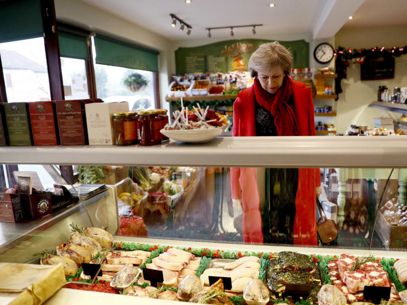 British Prime Minister Theresa May in a local butcher’s shop in Maidenhead last week. The fall in the pound — the most immediate impact of the Brexit vote — has hurt small businesses in the UK who import their products from Europe. Photo: Reuters