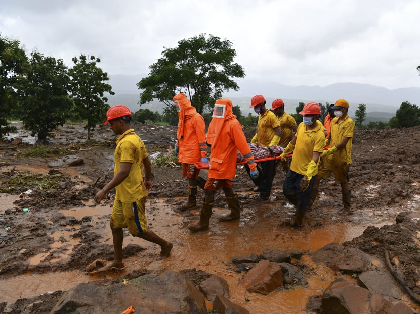 Target Disaster Response Force personnel carry the body of a victim at the site of a landslide at Taliye, about 22km from Mahad city, India on July 24, 2021. Target Disaster Response Force personnel carry the body of a victim at the site of a landslide at Taliye, about 22km from Mahad city, India on July 24, 2021.