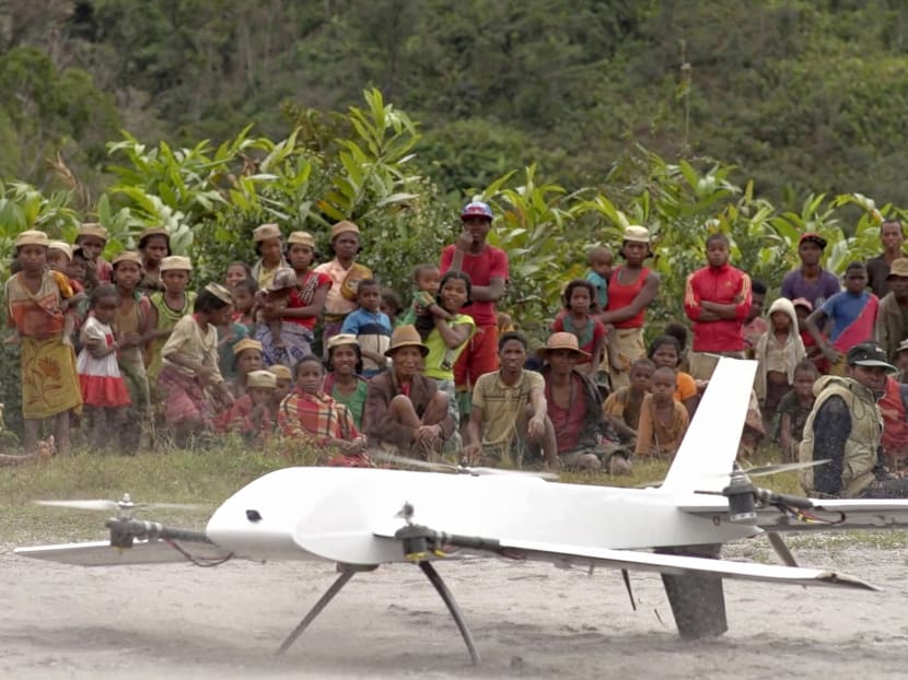 In this July 27, 2016 image made from a video provided by Vayu, Inc., residents from Ranomafana, Madagascar, watch before a drone containing medical samples takes off on a test flight from their remote village, which can only be reached on foot. Photo: Stony Brook University/Vayu Inc. via AP
