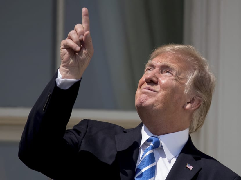 US President Donald Trump points to the sun as he arrives to view the solar eclipse, on Aug 21, 2017, at the White House in Washington. Photo: AP