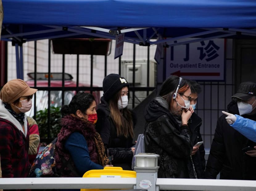 A woman takes a rapid antigen test for Covid-19 at an entrance of a hospital, as Covid outbreaks continue in Shanghai, China, on Dec 12, 2022. A woman takes a rapid antigen test for Covid-19 at an entrance of a hospital, as Covid outbreaks continue in Shanghai, China, on Dec 12, 2022.