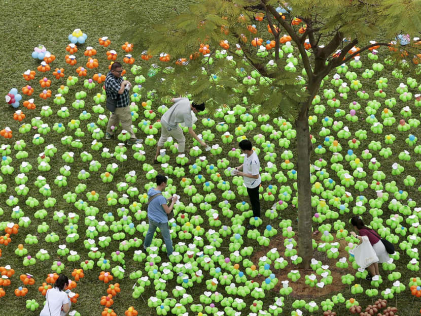 Participants at the We Care ‘Big Tree’ Balloon Sculpture, made up of 1,000 balloons twisted into the shape of flowers, at the Tanjong Pagar GRC and Radin Mas SMC Tree Planting Day event held at Leng Kee Park yesterday. Photo: Jason Quah