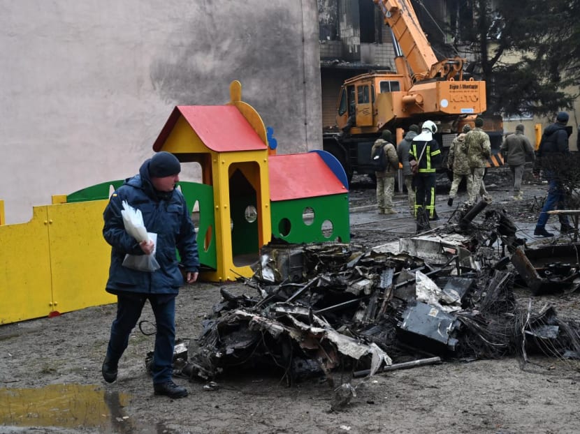 Firefighters work near the site where a helicopter crashed near a kindergarten in Brovary, outside the capital Kyiv, killing Sixteen people, including two children and Ukrainian interior minister, on Jan 18, 2023.