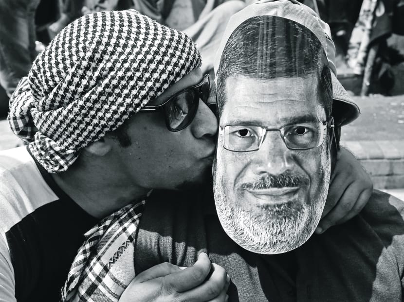 A supporter of Egypt’s ousted President Mohamed Morsi kisses a friend wearing a Morsi mask during a demonstration last week. Despite the recent massive protests against the leader, he had received great electoral support. Photo: AP
