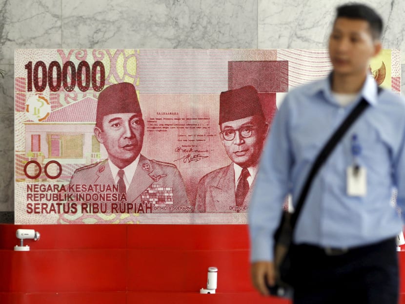 A man walks past a large display of a one hundred thousand rupiah banknote inside the Bank Indonesia complex in Jakarta, Indonesia. Reuters file photo